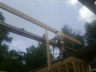 Carpenter setting a ridge beam over a new addition frame — Ice Dam Removal by Roofing Brothers in Belgrade