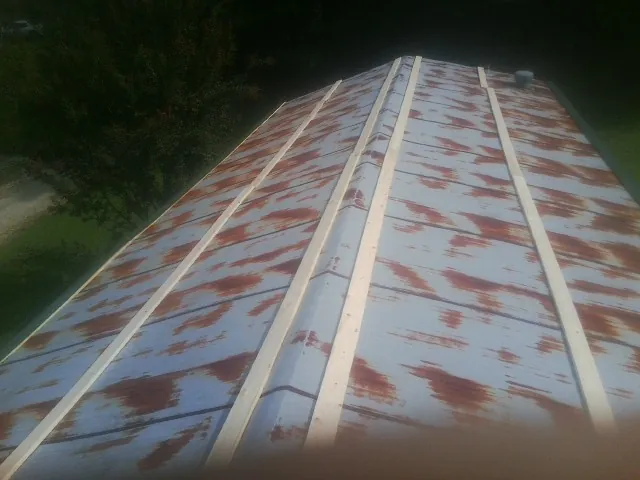 Rusted metal roof panels with new wood purlins before replacement — Storm Damage Roof Repair in Belgrade by Roofing Brothers