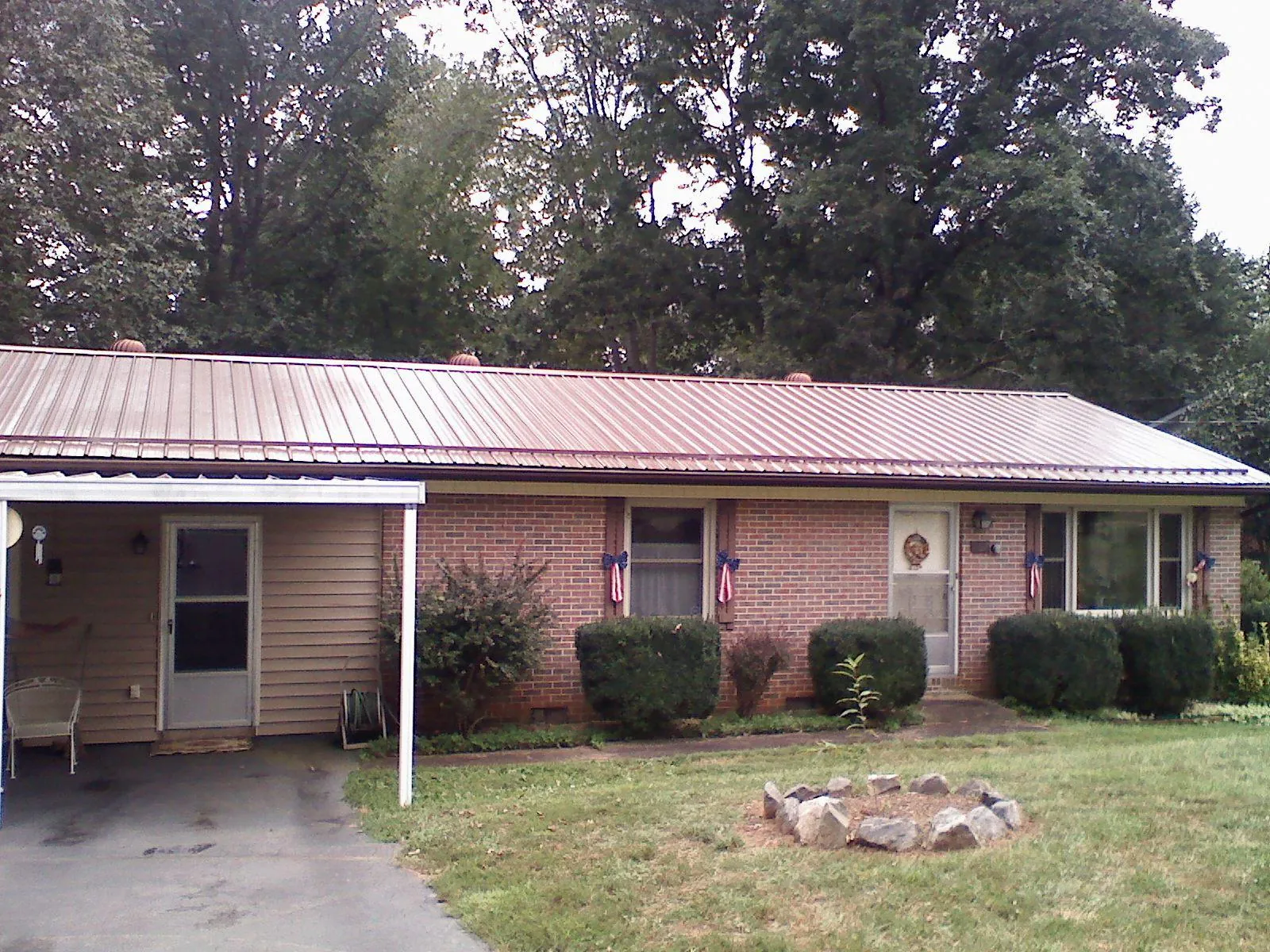 Bronze metal roof and carport on a brick ranch home — Roof Repair work by our crew in Belgrade